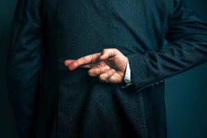 Lying businessman holding fingers crossed behind his back