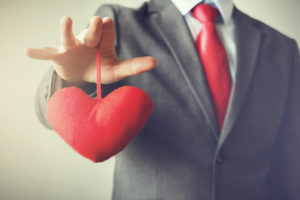 Businessman winning and controling customer's heart concept in Vintage tone